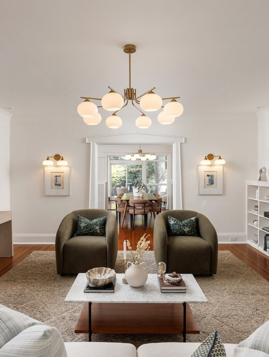 Dining room staged by Willow & Dove Studios: brass chandelier, green velvet chairs and a neutral rug