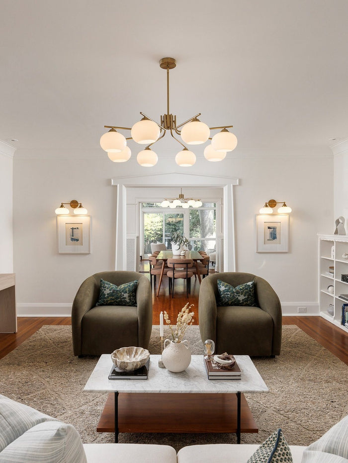 Dining room staged by Willow & Dove Studios: brass chandelier, green velvet chairs and a neutral rug