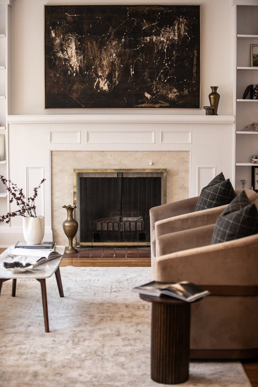 Living room staged by Willow & Dove Studios with a fireplace, abstract art and two armchairs